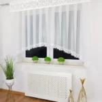 Elegancka nowoczesna firana z panelem i gipiurą zdobiona płatkami woalu