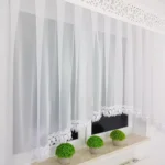 Elegancka nowoczesna firana z panelem i gipiurą zdobiona płatkami woalu
