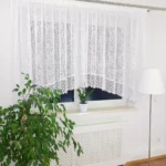 Modna firanka z żakardu zdobiona gipiurą, uszyta w łuk